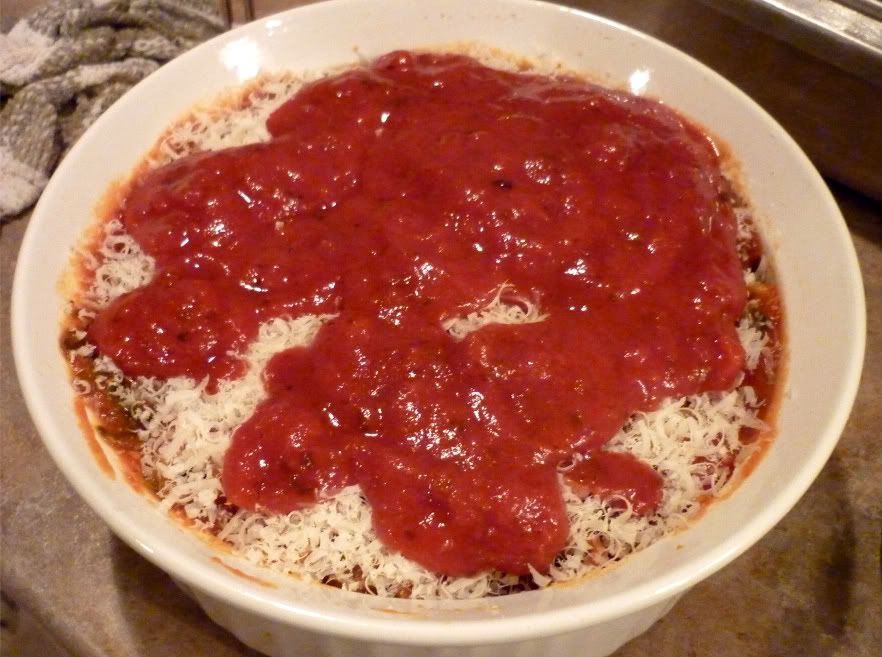 Baked rigatoni tube pasta with holes in them - standing up in baking dish with cheese and sauce